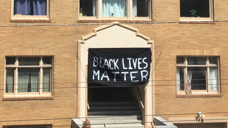 A Black Lives Matter banner hangs on the front of a brick building
