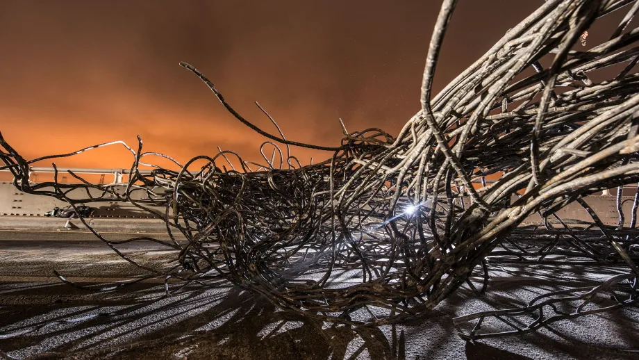 A bundle of recently removed rebar appears as an abstract sculpture against the twilight sky. 