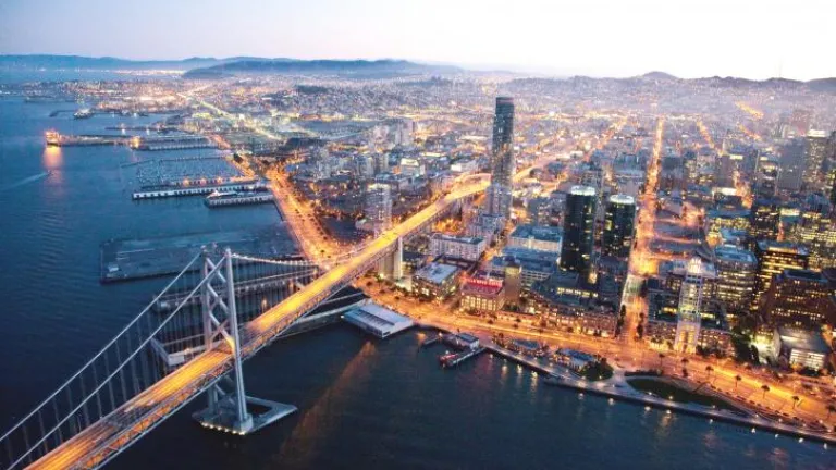 Aerial photo of West Span of Bay Bridge and lighted streets of San Francisco