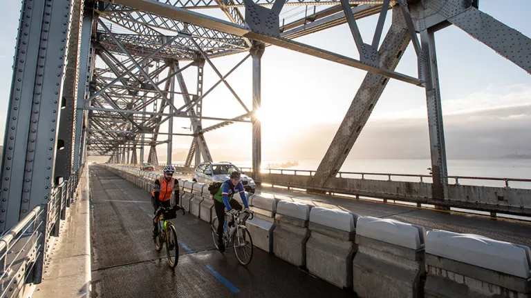 Two cyclists riding on the Richmond-San Rafael Bridge bicycle/pedestrian path.