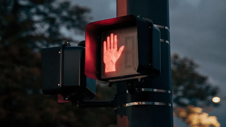 Electronic "don't walk" sign with an illuminated red hand.