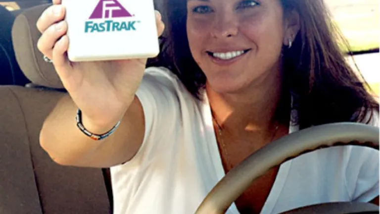 Woman affixing Fastrak toll tag to windshield