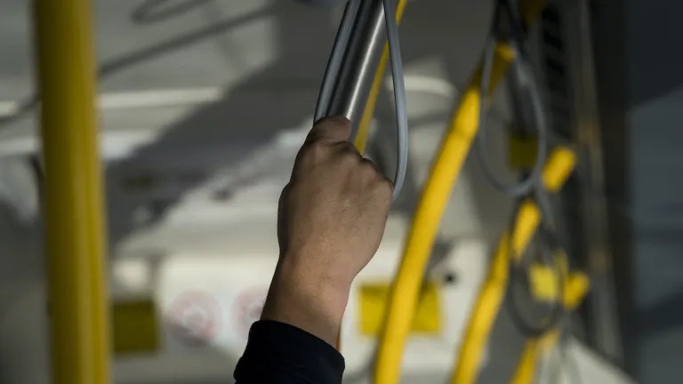Holding a hand strap on a bus