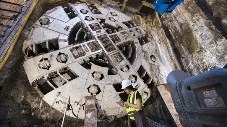 A construction worker stands in front of the tunnel boring machine in the tunnels that will become the Muni Central Subway in San Francisco.