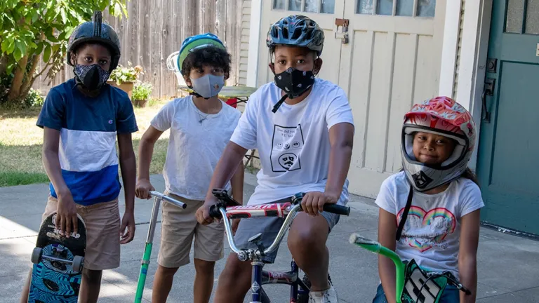  Kids with bikes, a scooter and a skateboard