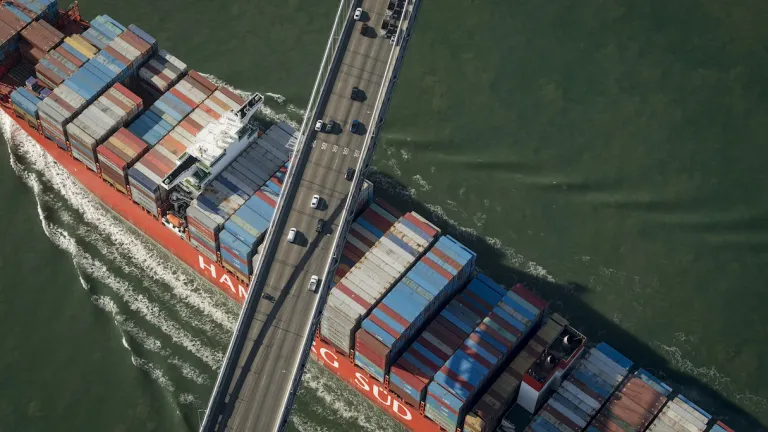 A cargo ship passing beneath the San Francisco-Oakland Bay Bridge