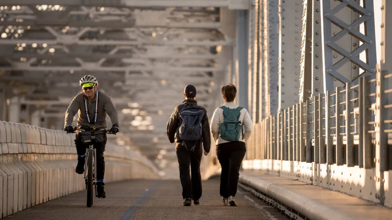 A cyclist and pedestrians on the Richmond-San Rafael bicycle/pedestrian path.
