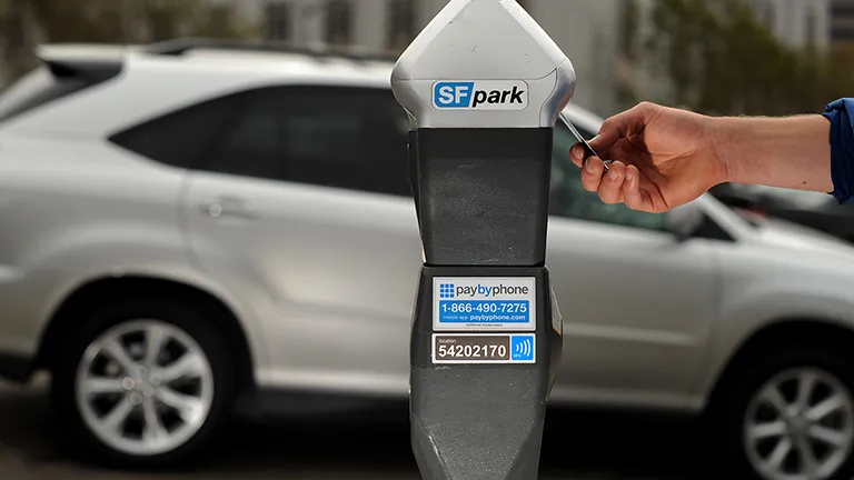 A person pays for parking at a parking meter in San Francisco.