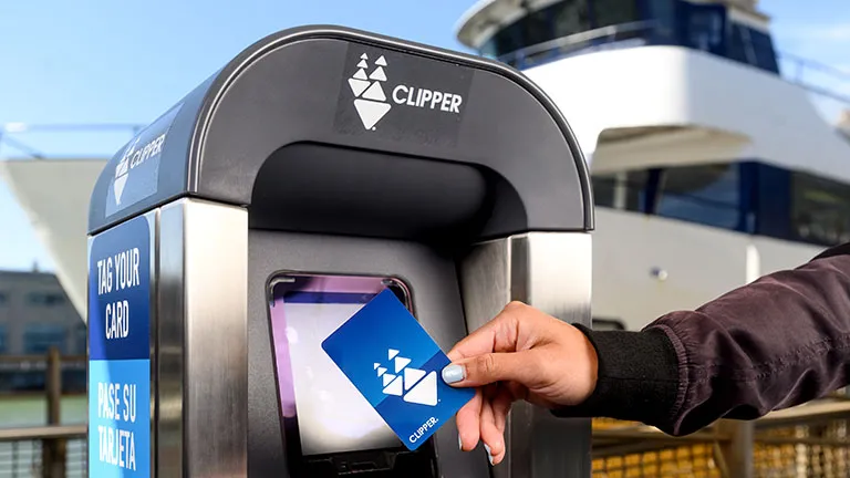 A person tagging their Clipper card at a ferry terminal.