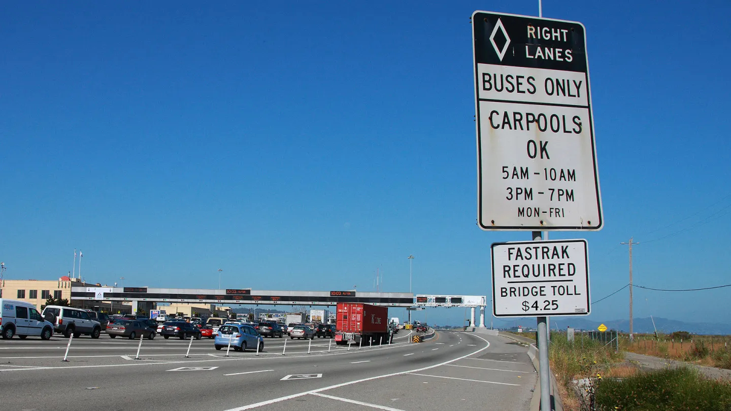 Sign indicating right lane is bus-only at the San Francisco-Oakland Bay Bridge toll plaza.