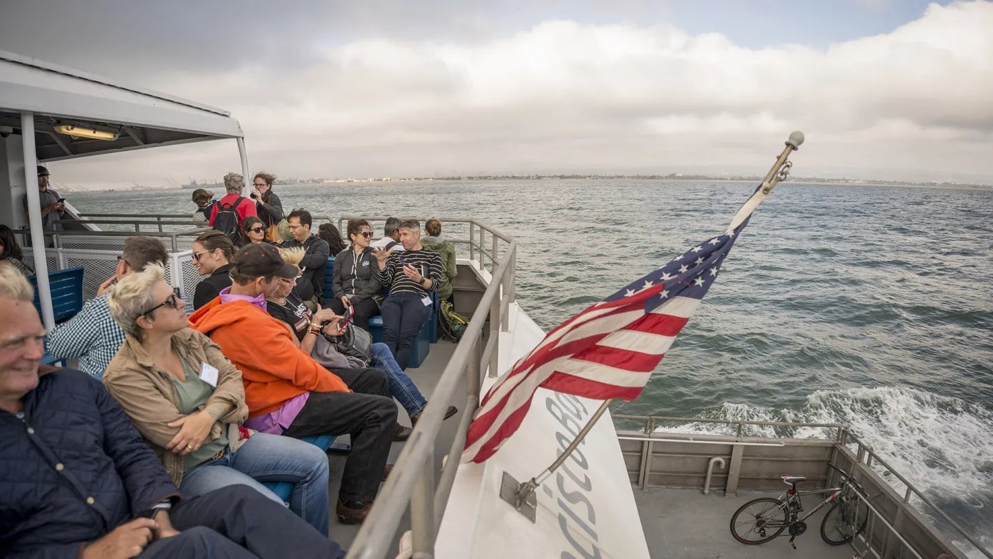 San Francisco Bay Ferry passengers and an American flag.