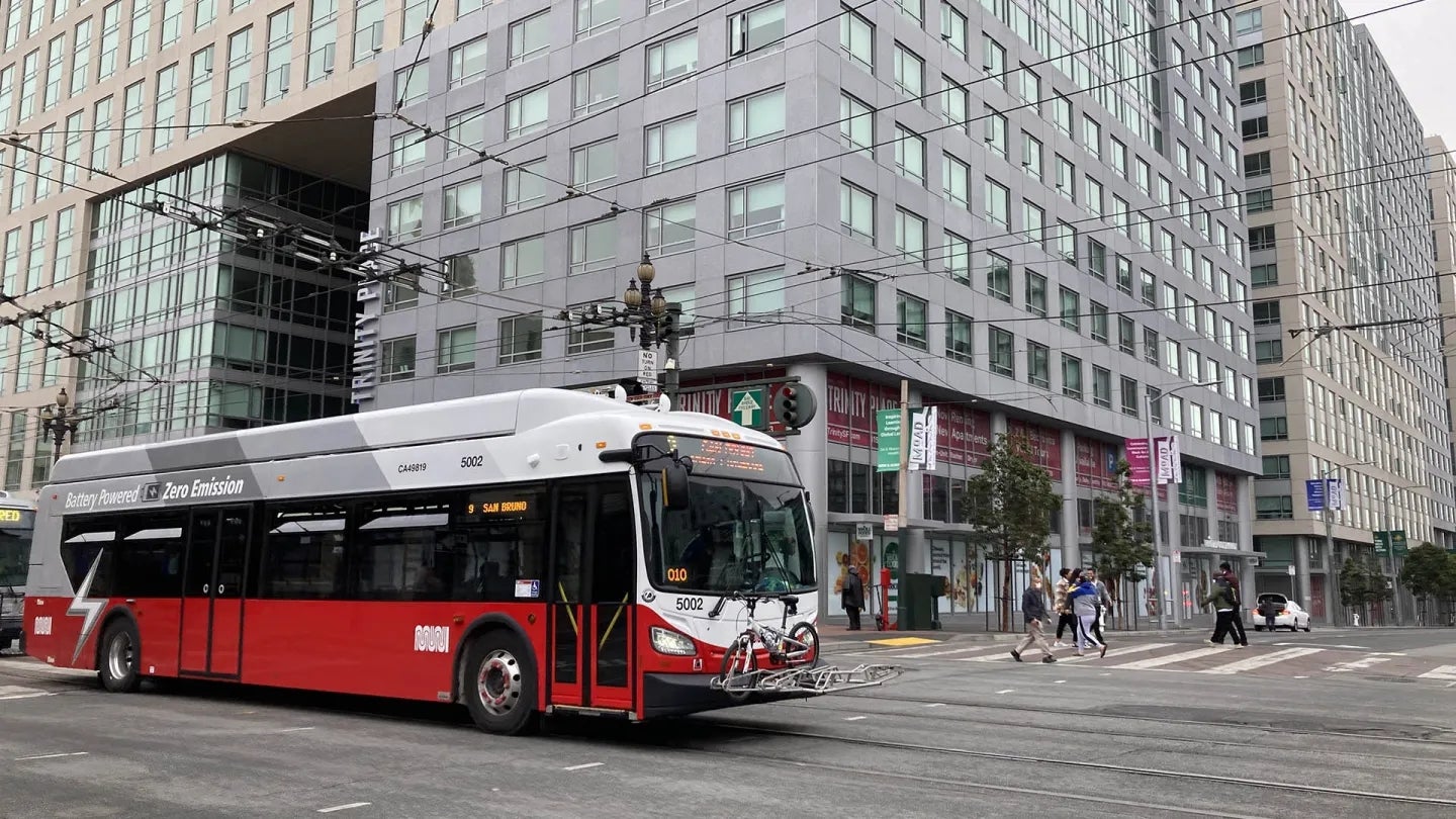 A battery-powered Muni bus near new housing on Market Street in San Francisco.