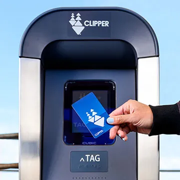 A person tags their card at a new Clipper card reader.