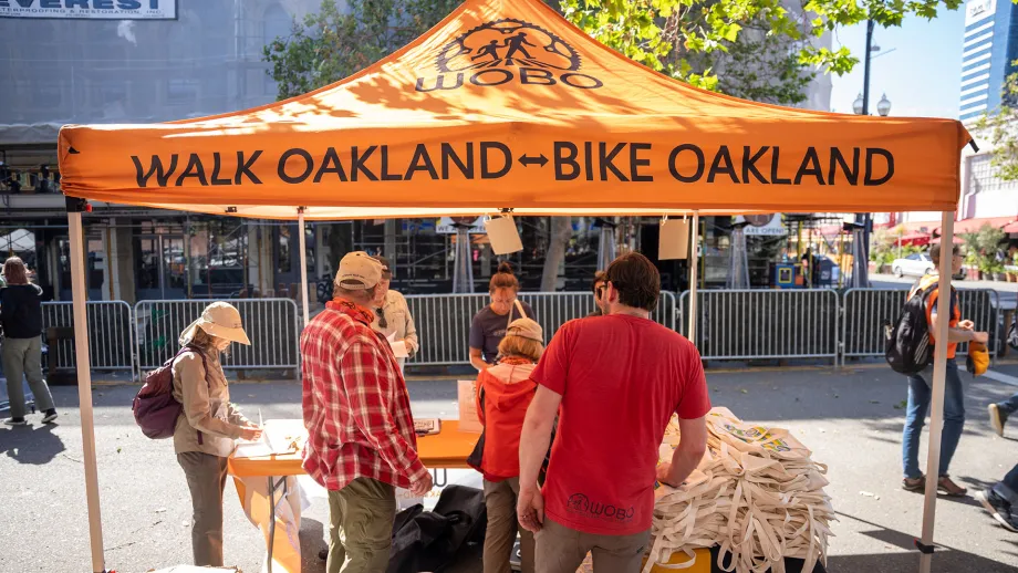 Volunteers under a Walk Oakland-Bike Oakland tent on Bike to Work Day.