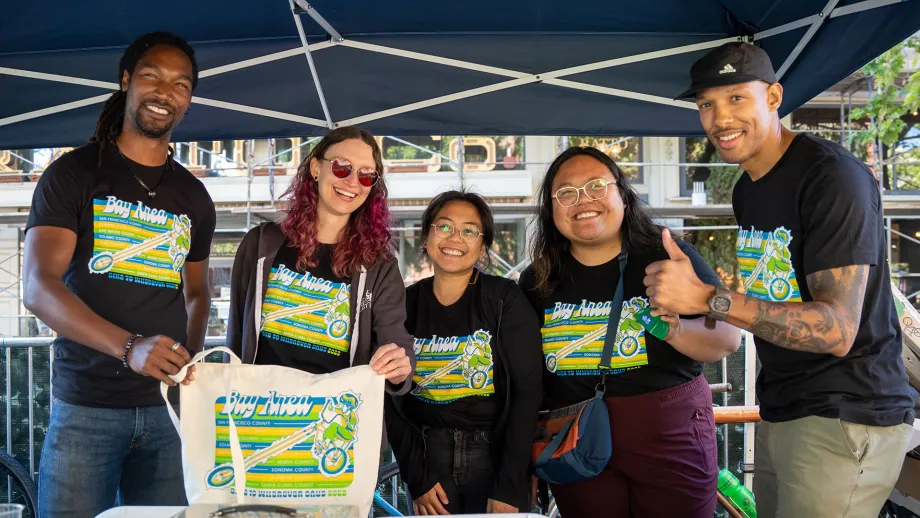 Smiling volunteers in Bay Area Bike to Work Day t-shirts.