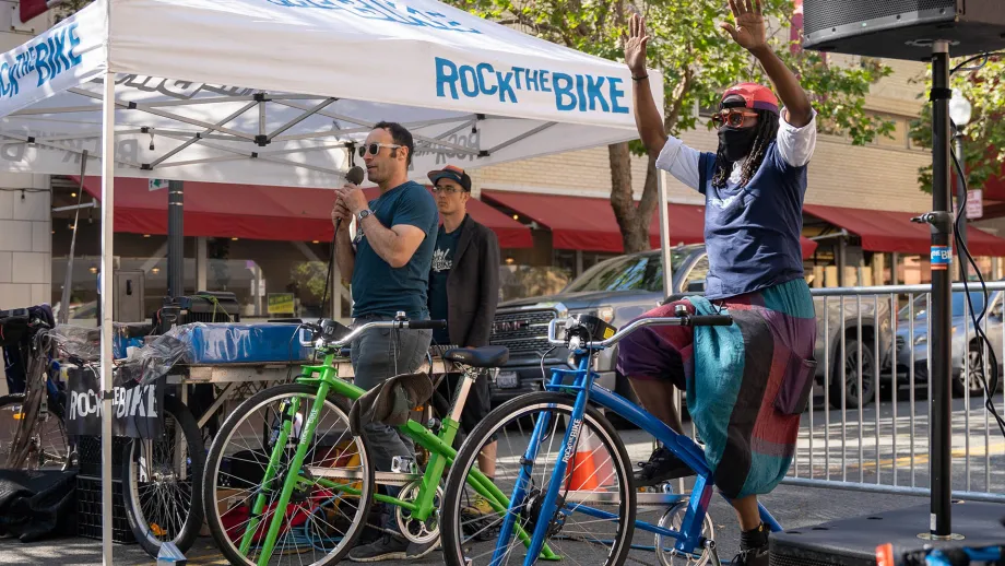 A person on a bicycle that is powering music at the Rock the Bike tent on Bike to Work Day.