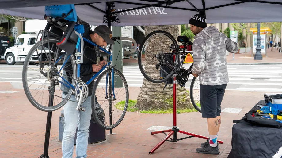 Two bicycle mechanics performing tune-ups on Bike to Work Day.