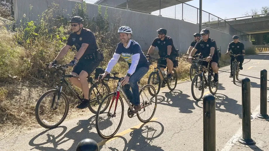 MTC Commissioner Matt Mahan rides along a bike path with members of the San Jose Police Department.