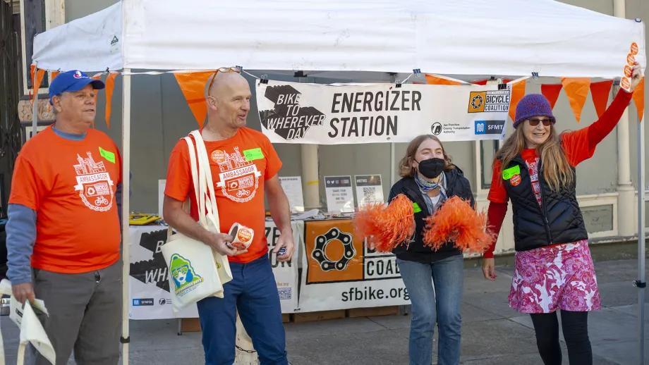 Volunteers cheering at a Bike to Work Day energizer station.