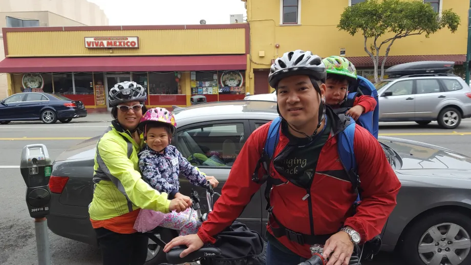 A family of bicyclists--two parents and two children--smile for the camera