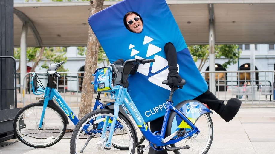 man dressed in clipper card costume on a go bike