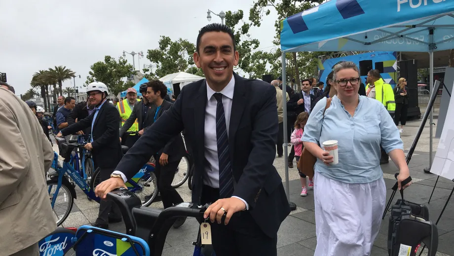 Man in suit trying out a go bike