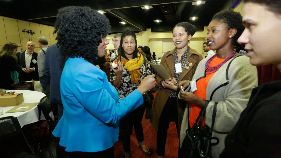 Economist Nela Richardson speaks with a group of forum attendees after her presentation.