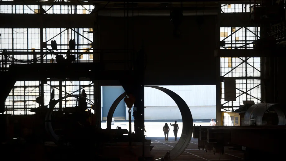 Workers walks through XKT Engineering's Mare Island facility. 