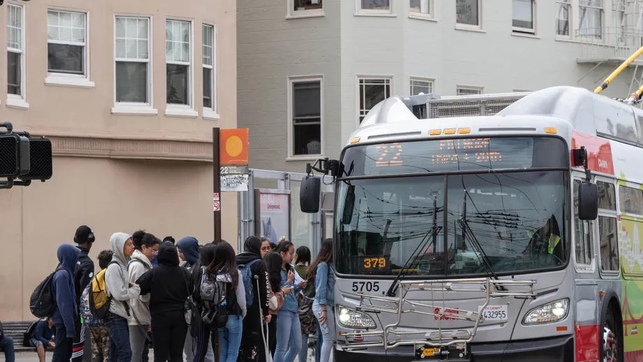A group of students boarding a Muni bus.