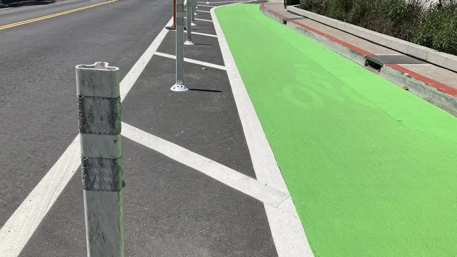 A separated bike lane protected with green paint and plastic hit posts.