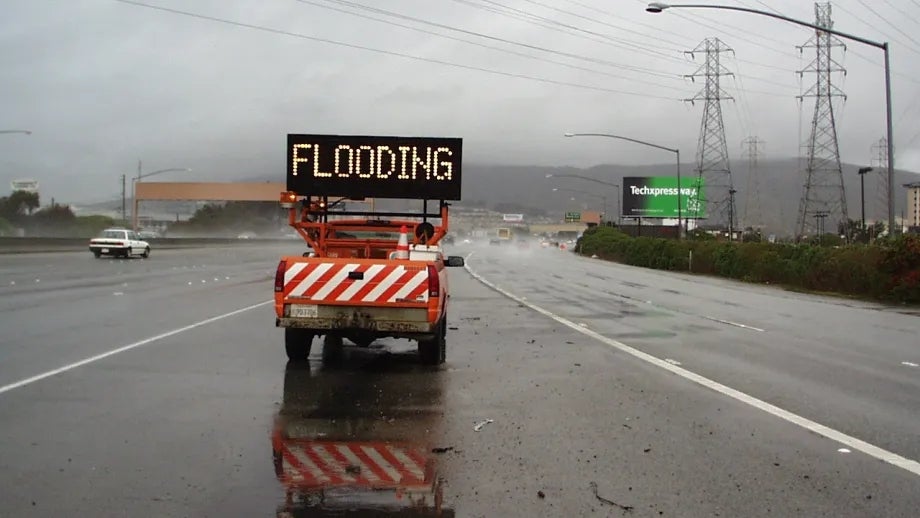 An LED roadway sign indicating flooding ahead.