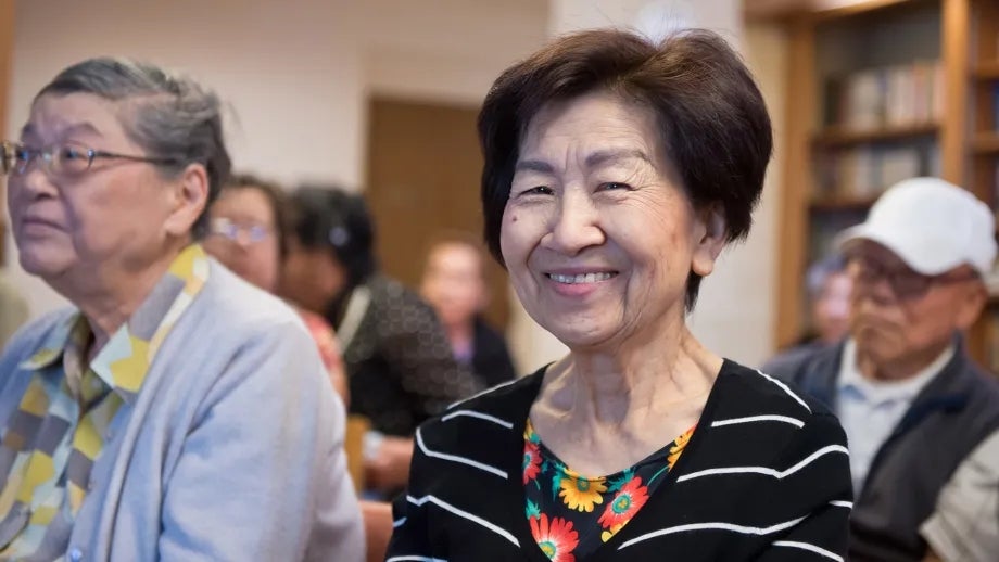 Smiling Asian seniors at a community event.