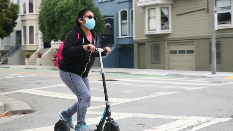 A woman riding a kick scooter.