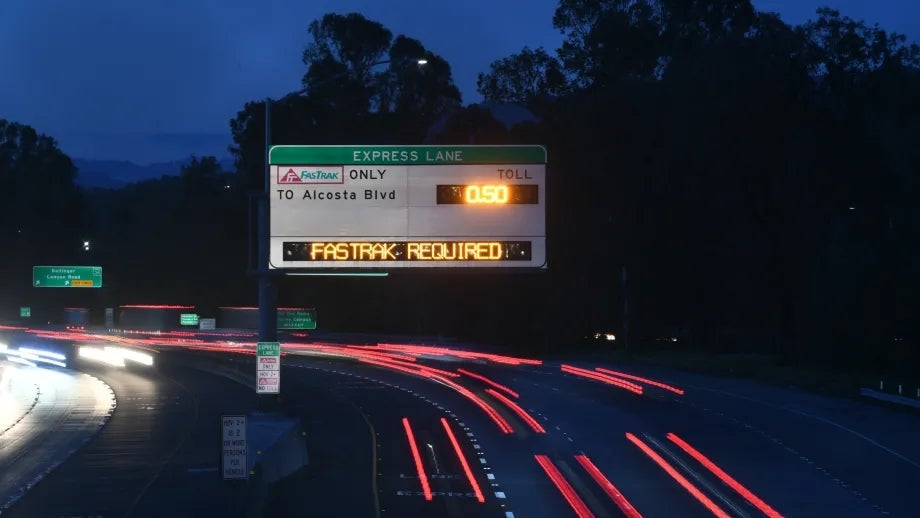 Illuminated neon sign indicating "FasTrak Required" hangs over Interstate 680.
