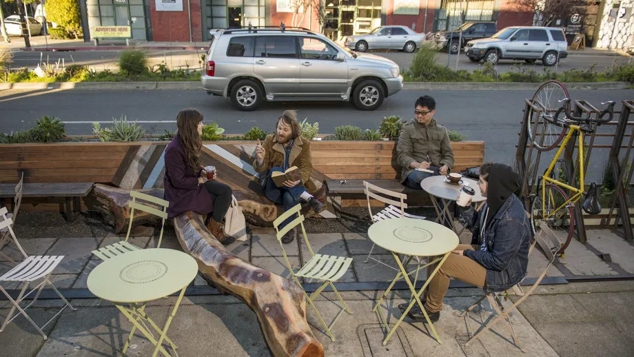 Diners enjoying a sidewalk "parklet" in Oakland.