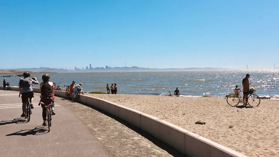 Cyclists and beachgoers enjoying the sun, sand and views of the San Francisco skyline at Golden Gate Fields beach in Albany.