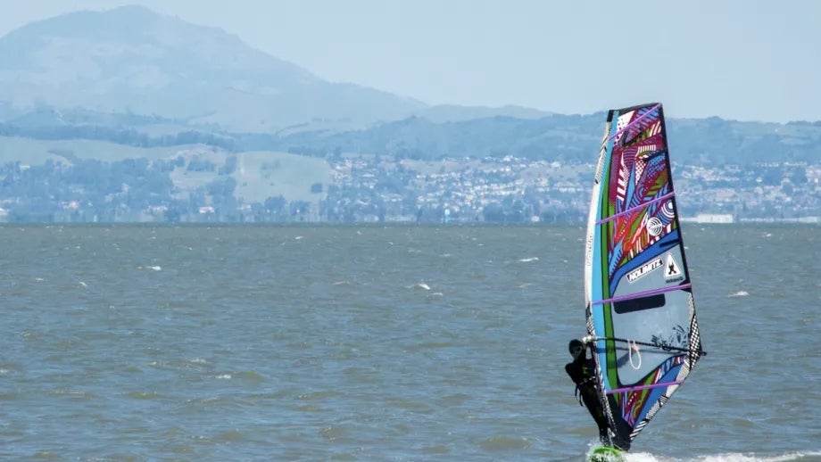 A sailboarder in a wetsuit on the San Francisco Bay.