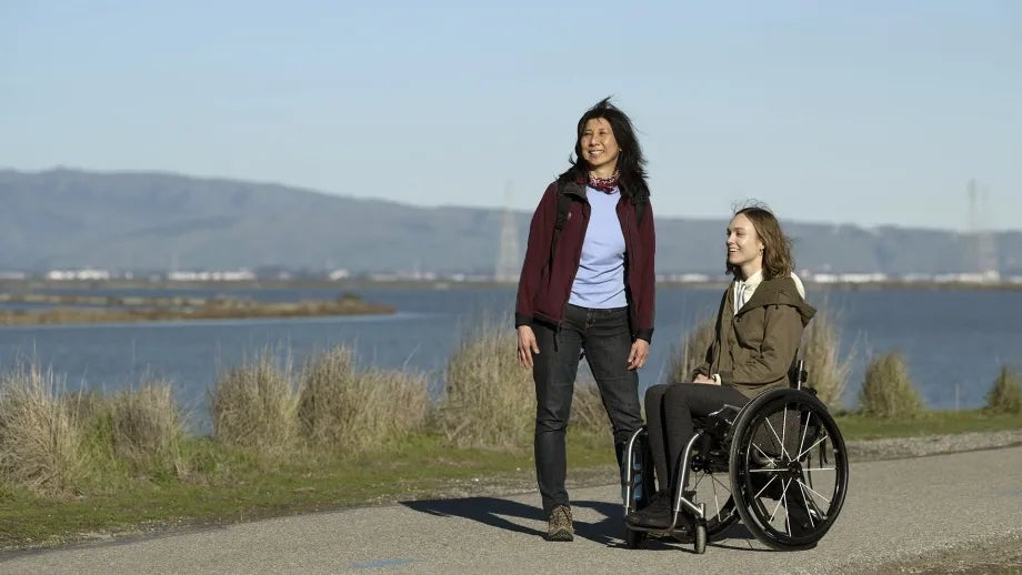 Two people enjoying the Bay Trail - one walking, one in a wheelchair.