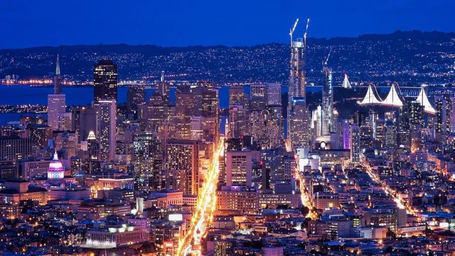 San Francisco skyline at night, with Market Street, the Salesforce Tower and Bay Bridge all visible.