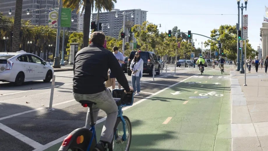 A person riding a Bay Wheels bike in a two-way protected bike lane in San Francisco.