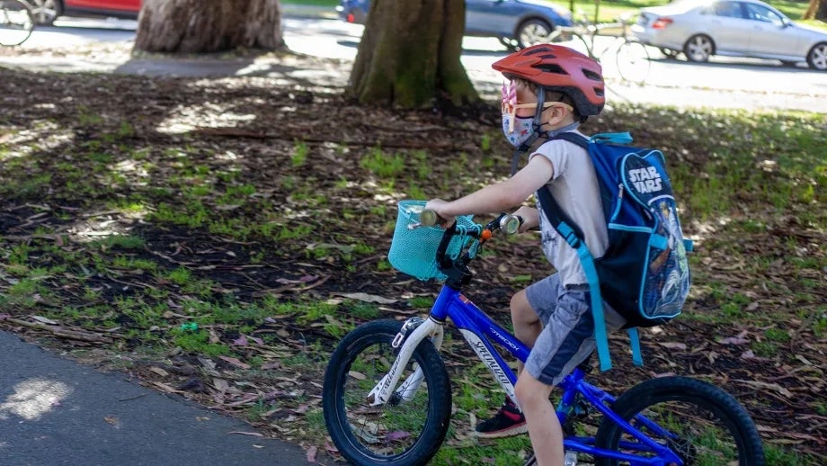 A young child rides a bike through San Francisco's Panhandle park.