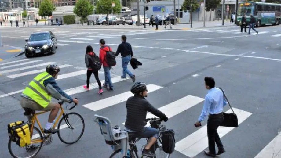 An intersection busy with pedestrians, cyclists and cars
