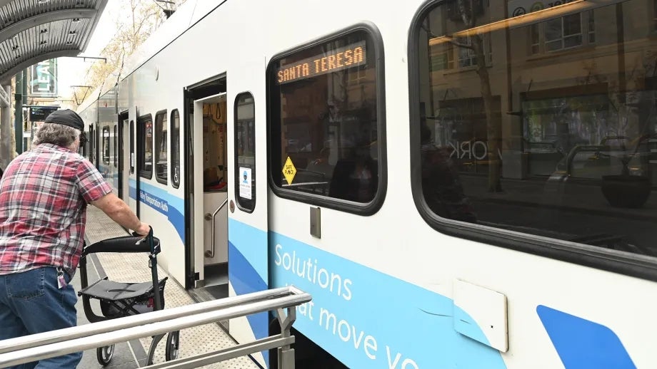 A person with a disability boards a VTA light rail train.