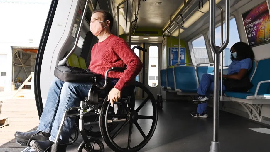 A man in a wheelchair is exiting a BART train.