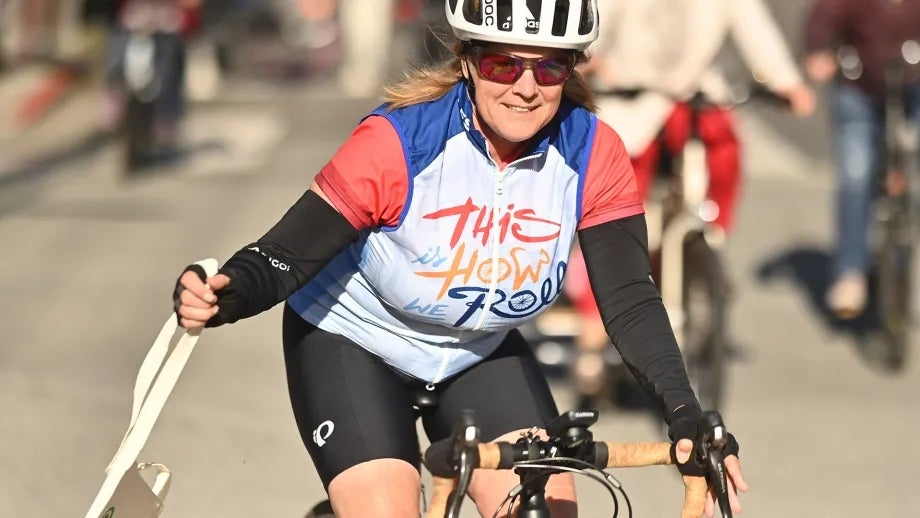 A happy woman in sport wear riding a bike.