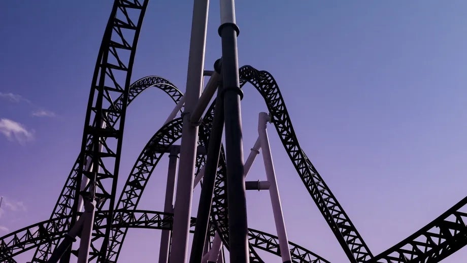 Silhouette of a roller coaster against a purple evening sky.