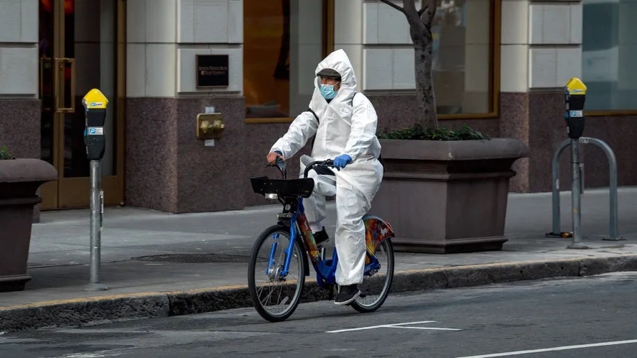 Covid-19 Crisis: A man wearing a protective suit while cycling